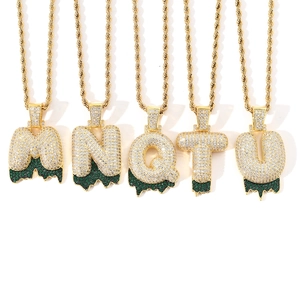 Detail of hip hop bubble letters M N Q T U with green dripping effects and cubic zirconia