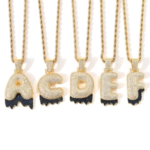 Close-up of hip-hop bubble letter pendants with white and blue cubic zirconia pavé