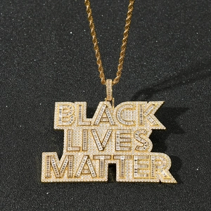 Detail of gold hip-hop pendant with Black Lives Matter slogan and shiny cubic zirconia