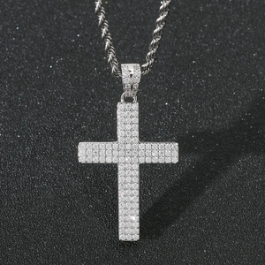 Detalle del colgante de cruz hip-hop con tres filas de circonitas pavé en cadena de cuerda