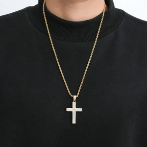 Detalle del colgante de cruz dorada con tres filas de circonitas brillantes para hombre