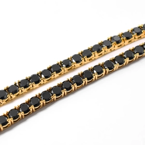 Makroansicht der 4mm schwarzen Zirkon Tennis Kette mit Goldbeschichtung und Krappenfassung