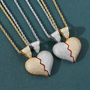 Detailed macro view of two-tone iced out broken heart pendants with cubic zirconia stones