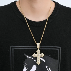 Détail du pendentif croix hip hop doré avec zircons sur une chaîne de type corde