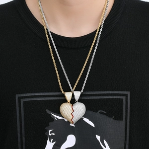 Detailed view of iced out broken heart necklaces with gold and silver rope chains on a model