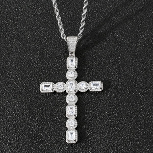 Détail macro du pendentif croix hip hop argenté avec zircons sertis et chaîne corde