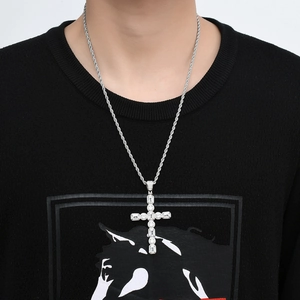 Gros plan d'un pendentif croix hip-hop argenté avec zircons et chaîne en corde