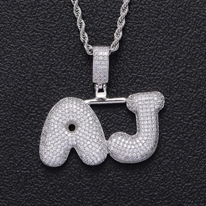 Gros plan du pendentif lettre AJ bulle argentée avec zircons sur chaîne torsadée