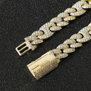 Macro detail van goudkleurige cubaanse schakelketting met zirkonia en baksluiting