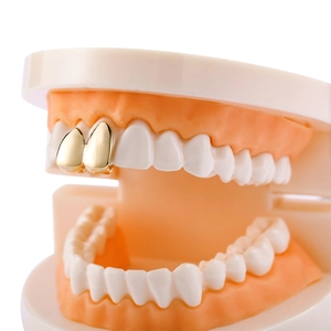 Grillz hip hop dorati per due denti anteriori con finitura metallica lucida su modello