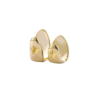 Vista macro di denti grillz hip hop dorati con dettagli di stelle pentagramma incise