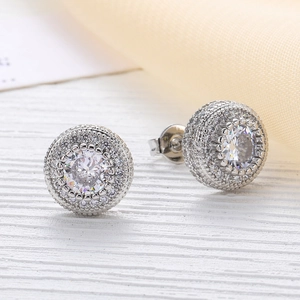 Detailed close-up of rose gold micro-pave zircon stud earrings with a central halo stone