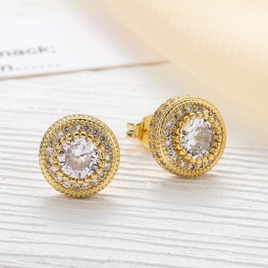Macro view of gold round zircon stud earrings with double row paved stones and back closure