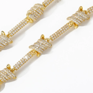 Macro view of gold-plated barbed wire chain link fully pavé set with white zircons