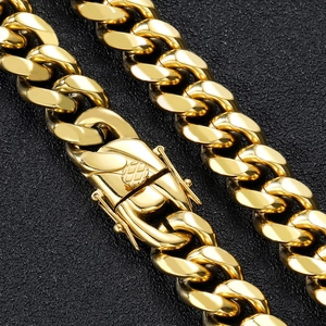 Macro shot of thick gold Cuban link chain with detailed box clasp on black background