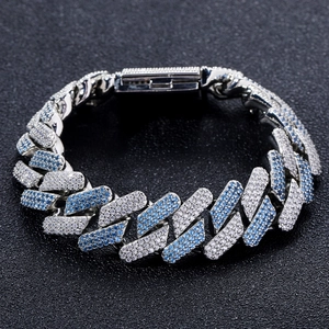 Silver Cuban link bracelet with blue and white zircons on a black textured background