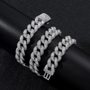 Close-up of 15mm silver iced out Cuban link chain with pave zircons on black stand