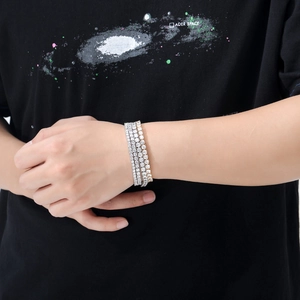 Détail de bracelets tennis argent et or avec zircons micro-pave sur le bras d'un modèle