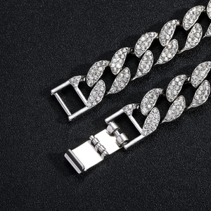 Macro shot of silver iced-out 15mm Cuban link chain with detailed fold-over clasp