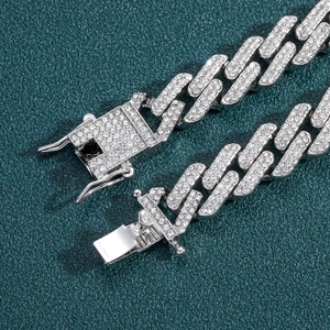 Gros plan d'une chaîne cubaine argentée de 14mm avec fermoir diamanté sur cuir vert