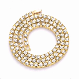 Detail of a gold tennis chain featuring round cubic zirconia in a prong setting