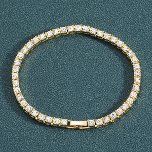 Classic golden tennis bracelet with round cubic zirconia on green leather background