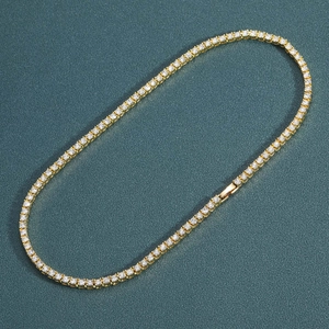 Detail of gold tennis necklace showing micro-paved rhinestones and secure safety clasp