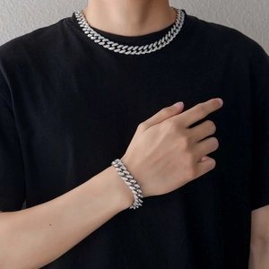Détail de l'ensemble chaîne cubaine et bracelet argenté avec des diamants étincelants