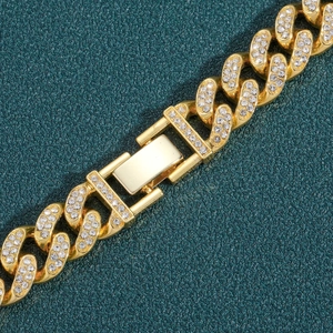 Gros plan sur un bracelet gourmette doré serti de strass avec boucle détaillée