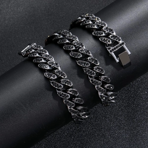 Vue détaillée de la chaîne cubaine 13mm avec diamants noirs sur un support cylindrique