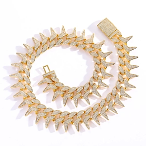 Macro detail of gold-plated cuban chain with sharp spikes and luxury zircon clasp