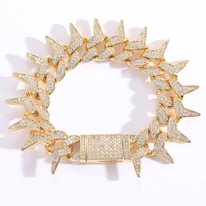 Detailed macro of gold spiked Cuban link bracelet with micro-pave cubic zirconia crystals