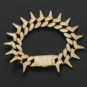 Macro shot of gold-plated spiked Cuban chain bracelet with cubic zirconia micro-pave