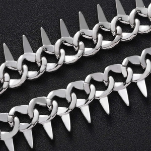 Macro detail of silver punk Cuban link chain with high-polish metallic spikes