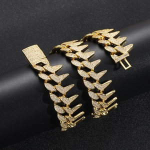 Macro shot of a gold-plated spiked Cuban link chain encrusted with zircon on a black stand
