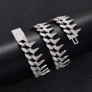 Macro detail of silver spiked Cuban chain with white zircon pavé and secure clasp