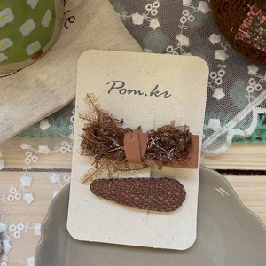 Vue macro détaillée d'une pince à cheveux vintage avec nœud, paillettes et chaîne en métal
