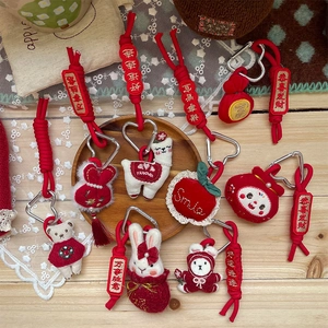 Cute red plush animal keychains with bear and rabbit charms on a white lace background