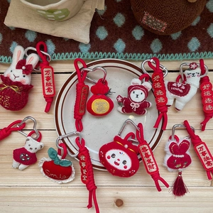 Plush red holiday charms with cute bear, rabbit, and fortune bag on wooden table