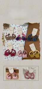 Close-up of handmade felt fruit hair rings with fine stitching on beige background