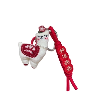 Cute plush alpaca keychain with red braided cord and good luck embroidery tag