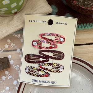 Detail view of 6-piece cute cartoon bear and leopard print BB hair clips on display card