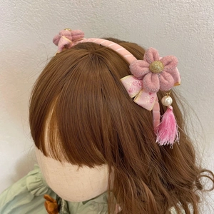 Detail van roze bloemen haarband met fluwelen bloemblaadjes, parels en kwastjes