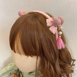 Detail van roze Chinese stijl haarband met bontballen, kwastjes en strik haaraccessoires