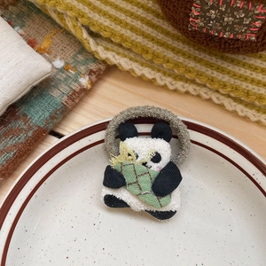 Gros plan d'un chouchou panda en peluche avec bambou posé sur une assiette