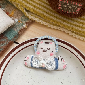Gros plan sur un élastique à cheveux ours en tissu fait main avec nœud bleu