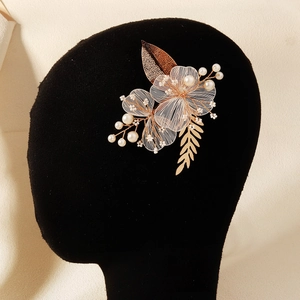 Détail macro d'une pince à cheveux de mariée avec fleurs en fil d'or et perles