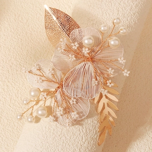 Détail de pétales en fil doré et perles sur un accessoire de cheveux mariage
