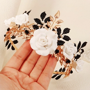 Detail of Halloween headband with white ceramic roses, black leaves and golden branches