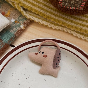 Vue détaillée d'un élastique en tissu fait main en forme de chien sur une assiette